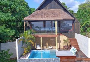 卢甘维尔Bombua Beach House的一座带游泳池和房子的别墅