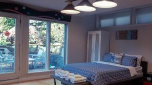 温哥华Van Nest near YVR UBC Downtown的一间卧室设有床和滑动玻璃门