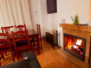 埃尔博斯克Dúplex con terraza en El Bosque的客厅设有壁炉、桌子和椅子