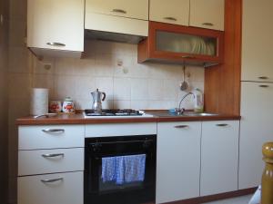 贾迪尼-纳克索斯玛丽亚焦万娜公寓的厨房配有白色橱柜和黑烤箱。