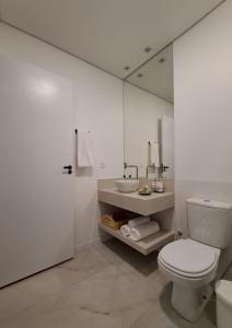 戈亚斯州上帕莱索Casa dos Lírios的白色的浴室设有卫生间和水槽。