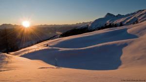 图拉彻霍赫My Turrach Grünsee Chalet by S4Y的一座雪覆盖的山,阳光照耀着