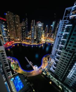 迪拜Amazing 1 bedroom apt in Marina的享有夜间城市与河流和建筑的景色