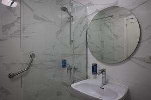 罗萨里奥港MC Apartments的带淋浴、盥洗盆和镜子的浴室