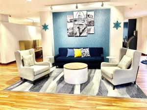 布里奇顿MainStay Suites St Louis Airport的客厅配有两把椅子和蓝色沙发