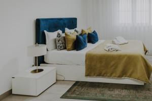奥良Apartamentos Sol & Ria的一间卧室配有白色的床和蓝色和黄色枕头