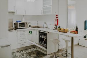 奥良Apartamentos Sol & Ria的白色的厨房配有柜台和微波炉