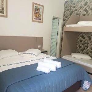 大普拉亚Pousada Aconchego na Praia的一间卧室配有两张床,在蓝色的床上配有毛巾