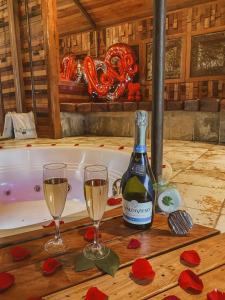 金特罗Hotel Boutique El Duende Mantagua的浴缸旁的桌子上放着一瓶葡萄酒和两杯酒