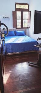 马尼萨莱斯LA MANSION的一间卧室配有一张带蓝色床单的床和一台电视。