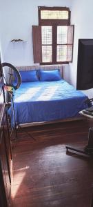 马尼萨莱斯LA MANSION的一间卧室配有一张带蓝色床单的床和电视。
