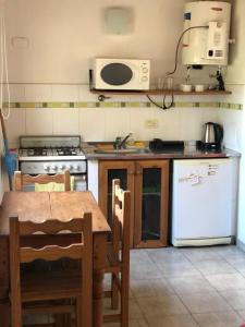 科隆El Aura的厨房配有桌子、炉灶和冰箱。