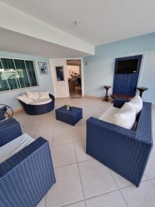 卡波布里奥Zênit Hostel da Cris的客厅配有蓝色椅子和沙发