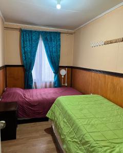 蓬塔阿雷纳斯Casa central en Punta Arenas的一间卧室设有两张床和窗户。