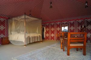 迪拜Al Marmoom Oasis “Luxury Camping & Bedouin Experience”的一间卧室配有一张天蓬床和一架钢琴