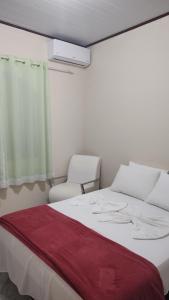 瓜皮米林Casa tia Rosa hospedagem familiar的卧室配有白色的床和2把椅子
