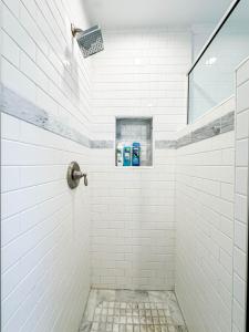 洛杉矶Modern 2-Bedroom Gem Close to Beverly Hills - DOH2的白色瓷砖淋浴间,配有2个蓝色牙刷