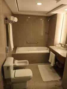 库里提巴White Plaza Hotel的浴室配有卫生间、浴缸和水槽。