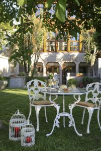 维亚纳堡卡萨曼努埃尔奥利维拉酒店的一张带两把椅子的白色桌子和一个鸟笼