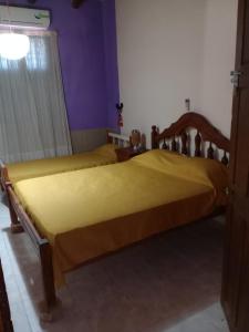 蒂诺加斯塔POSADA CUATRO HERMANOS的两张睡床彼此相邻,位于一个房间里