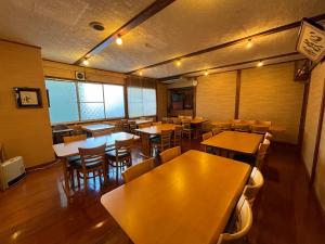 野沢内田屋旅馆的一间空餐厅,配有木桌和椅子