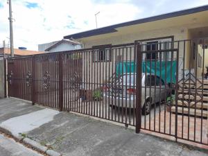 圣若泽杜斯坎普斯Hostel Sancris 2的房屋前有围栏,有停车位