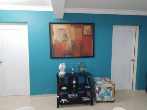 璜多里奥Acogedor apartamento a un paso de la playa的一间有蓝色墙壁的房间,上面有绘画