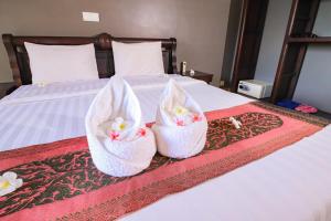 白马市Riviera Hotel & Resort Kep的两篮鲜花坐在床上
