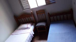 圣若泽杜斯坎普斯Hostel Sancris 2的一间小卧室,配有两张床和窗户