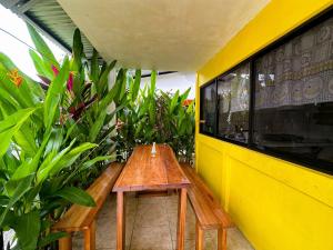 别霍港Casitas Coloradas Puerto Viejo的黄色墙壁前的木凳