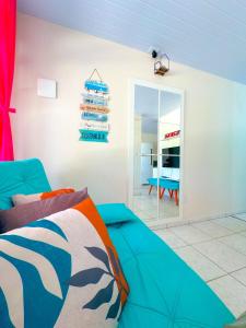 帕罗卡Casa de Anita Pinheira 30m da praia的客厅配有蓝色的沙发和镜子