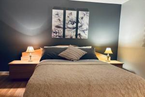拉瓦尔Ahava, Centropolis Laval的卧室配有一张墙上三幅画作的床
