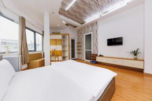 河内Lamaison Hà Nội的一间白色卧室,配有一张大床和一台电视