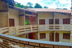 穆隆古Ap Classic - Pousada Flor da Serra - Mulungu的一个带木甲板的房子的阳台