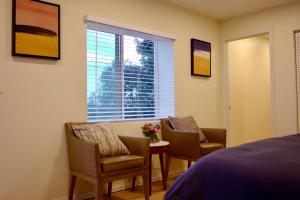 洛杉矶Hollywood Hills Haven-Guest House的一间卧室配有两把椅子、一张桌子和一个窗户。