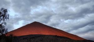 维库尼亚Cabaña equipada a 300 metros del observatorio mamalluca的阴天下的一个红色大金字塔
