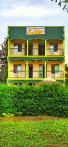 RubiriziLights of kazinga orphanage and homestay的山顶上一座黄色和绿色的建筑