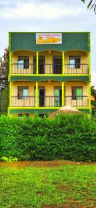 RubiriziLights of kazinga orphanage and homestay的山顶上一座黄色和绿色的建筑