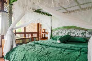 哲帕拉哈瑞曼尼斯小屋的一间卧室配有一张带天蓬的绿色床