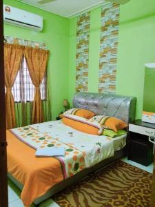怡保Syukur Homestay Ipoh的绿色墙壁客房的一张床位