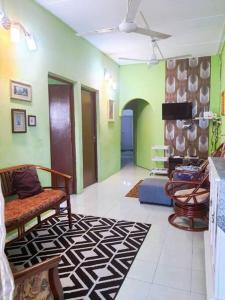 怡保Syukur Homestay Ipoh的客厅配有椅子和绿色墙壁