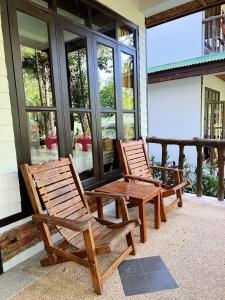 通塞海滩Dream Valley Resort, Tonsai Beach的两把木椅坐在房子的门廊上