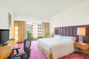 海得拉巴海得拉巴万怡酒店 的酒店客房设有一张大床和一台电视。
