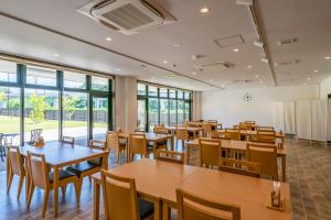 Tōna奥松島LANEホテル的用餐室设有桌椅和窗户。