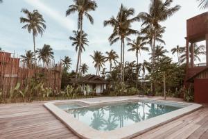 CatangnanALON CLOUD9, beach front的棕榈树房子后院的游泳池