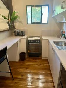 爱妮岛TukoKubo的厨房配有白色的柜台、炉灶和水槽。