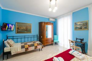 里波斯托Casa delle Zammare Fronte mare centro storico的一间卧室设有两张床和蓝色的墙壁