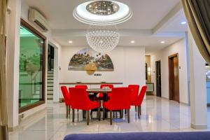 瓜埠Kuah Town - Villa Indah的一间带红色椅子和吊灯的用餐室