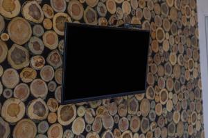 马塔兰Jepun Guest House的挂在木墙上的平面电视