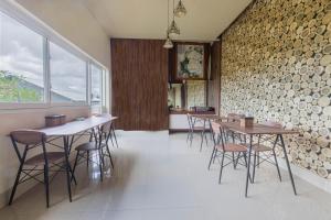马塔兰Jepun Guest House的一间设有桌椅的用餐室和砖墙